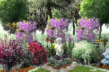 Garden design:Garden in corner of fenced yard with angel statue + trees behind fence. Garden design:My Corner Garden